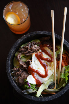 Bibimbap Bowl With Chopsticks And Drink, Overhead View