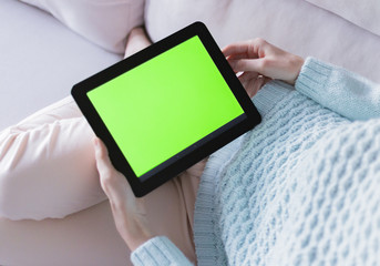 Woman at home relaxing reading on the tablet computer