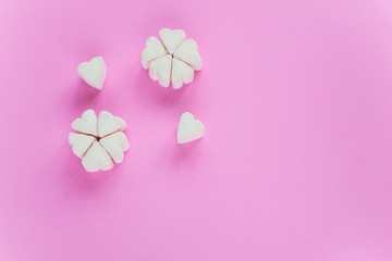 Marshmallows in heart shapes for Valentines day over pink paper background grouped like sakura flower to celebrate sweet love candy for couples