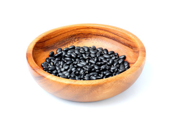 Wooden bowl with of haricot black beans isolated.