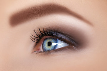 blue woman eye with beautiful brown shades