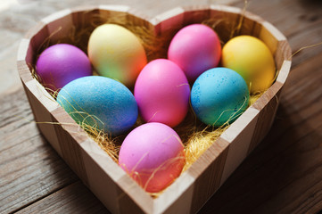 Obraz na płótnie Canvas Easter symbol - heart shaped bowl full of colored eggs