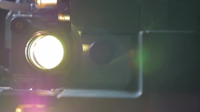 Film projector. Old movie projector working in dark. Dolly shot. 4K.