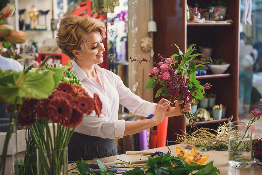 Inspired woman creating bouquet in workshop