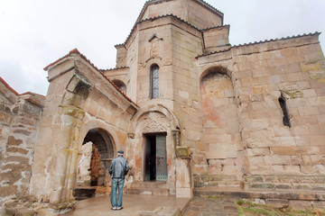 Man praying at entrance of Jvari Monastery, built in 6th century in Mtskheta, Georgia. World Heritage site by UNESCO