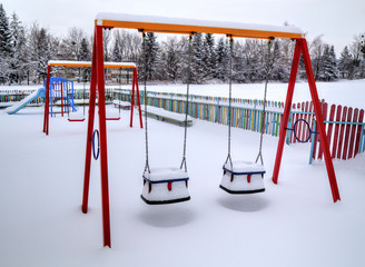 Children's playground covered with snow in winter