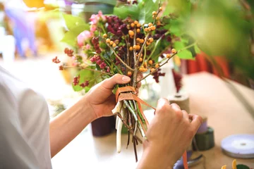 Abwaschbare Fototapete Blumenladen Verkäuferin rollt von Klebeband-Bouquet
