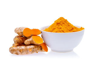 Turmeric roots and turmeric powder in white bowl