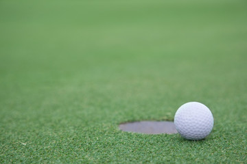 golf ball on lip of cup