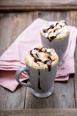 S'mores drink. Two mugs of hot chocolate with marshmallows on a wooden table. Cocoa.