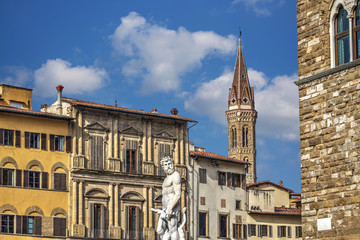 Fototapeta na wymiar Neptune statue and Badia Fiorentina steeple