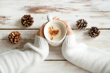 Holding warm coffee on a winter day. Woman hands. Top view