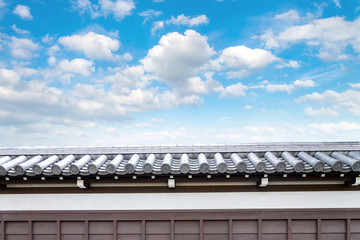 Ancient Traditional Japanese stone wall and old tiled roof from