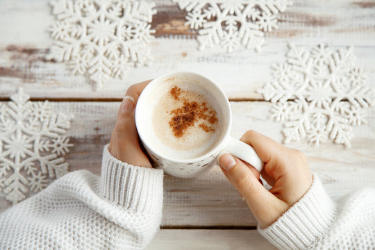 Holding warm coffee on a winter day. Woman hands. Top view