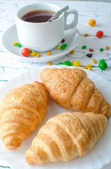 Tea on the table with croissants and scattered caramel