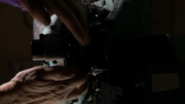 Film projector. Cameraman setting old movie projector. 4K