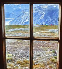 View through vintage window frame at picturesque norwegian mountains and fjord. Norwey, Hardangervidda national park, location at famous travel destination Trolltunga landmark.