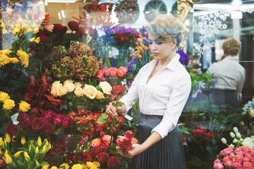 Rolgordijnen Bloemenwinkel Calm woman making bouquet in shop