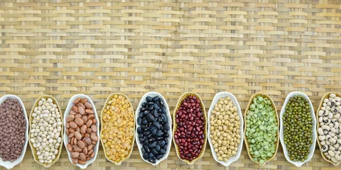 Foto op Canvas Different dry legumes on ceramic container in a row,  Prepared various dried bean on ceramic plate with bamboo woven © peangdao