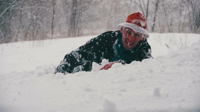 Man dives head first into the Deep Snow and Have Fun in the Winter Forest. Slow Motion