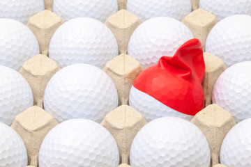 White golf balls in the box for eggs. Golf ball with funny cap.
