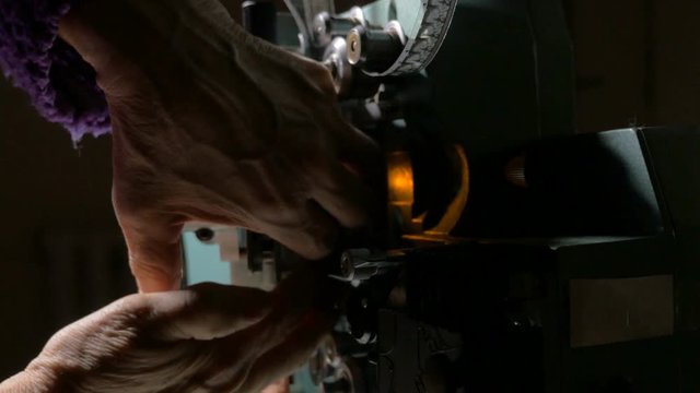 Film projector. Cameraman setting old movie projector. 4K