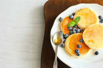 Tasty pancakes with blueberry on kitchen table
