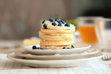 Tasty pancakes with blueberry on kitchen table