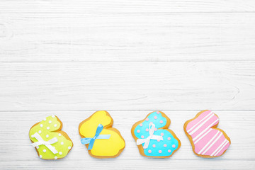 Colourful tasty Easter cookies in a row on white wooden background