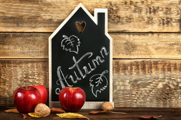 Beautiful autumn composition with chalkboard on wooden background