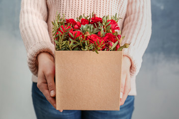 Woman holding beautiful roses in gift box, closeup