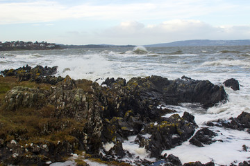 Fototapeta na wymiar Angry waves break over the rocks on the beach at Bangor Northern Ireland during a storm in the Irish Seah