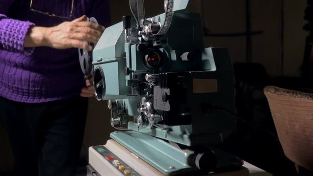 Film projector. Cameraman setting old movie projector. 4K