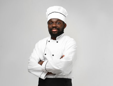 African American chef in uniform on light background