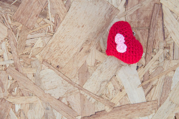 Red heart with bow tie on wooden background