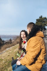 Beautiful young couple in love enjoying together, while man giving a rose to his girlfriend. 