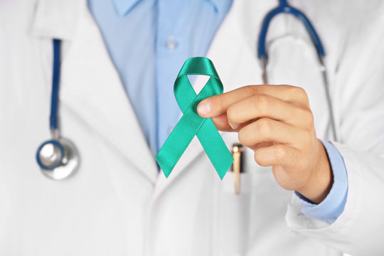 Doctor holding green ribbon, close up view. Kidney cancer and mitochondrial diseases concept