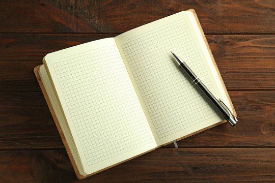 Opened notebook on wooden background
