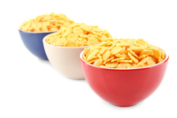 Bowls with cornflakes on white background