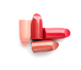 Broken lipsticks on white background