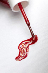 Brush of red nail polish.