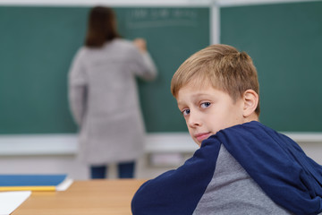schüler schaut mit fragendem gesichtsausdruck nach hinten
