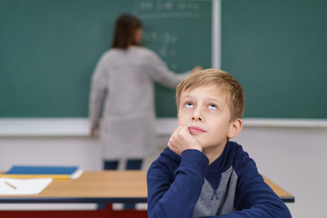 nachdenklicher junge in der schulklasse