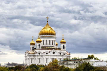 Cathedral of Christ the Saviour under dramatic clouds in Moscow. Gleaming domes top this Catholic edifice, rebuilt in the 1990s, with ornate, fresco-lined interior.
