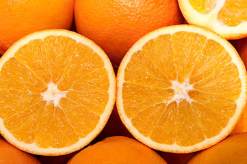 Half cut oranges in a pile of other ones