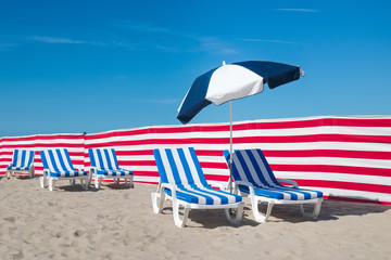 Stripy beach chairs against deep blue sky