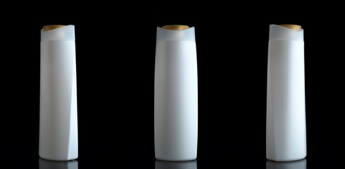 three shampoo bottle on black background with reflection