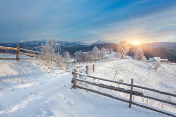 Winter country landscape with timber fence and snowy road