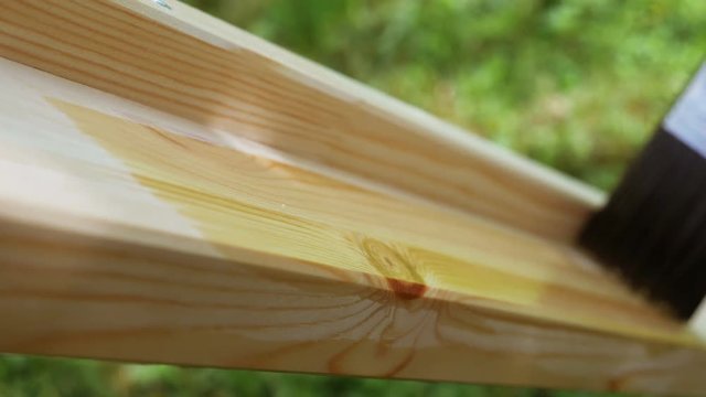 4K footage. Close-up paintbrush varnishing wooden plank