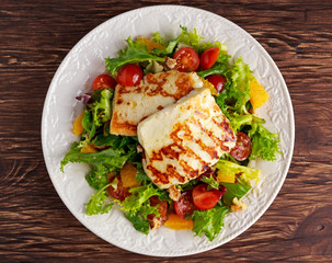 Grilled Halloumi Cheese salad witch orange, tomatoes and lettuce. healthy food
